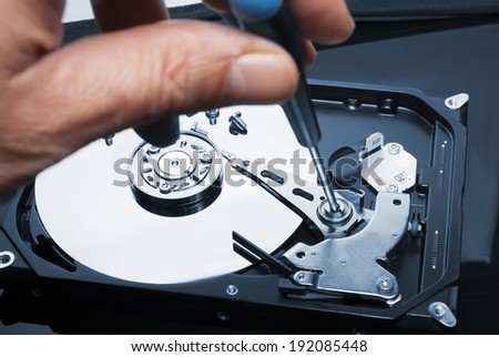 Man hand with screwdriver fixing or repairing hard drive or hard disc