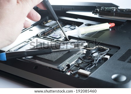 man fixing computer or laptop or notebook with crewdriver