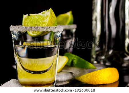 Tequila with lemon or lime and salt on reflex background
