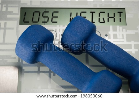 Two blue dumbbells on weighing machine with sign lose weight
