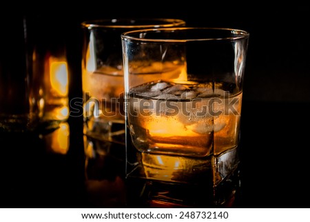 Whiskey, bourbon or brown rum on black reflection background
