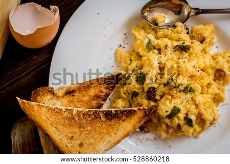 Traditional breakfast scrambled eggs with bacon and onion