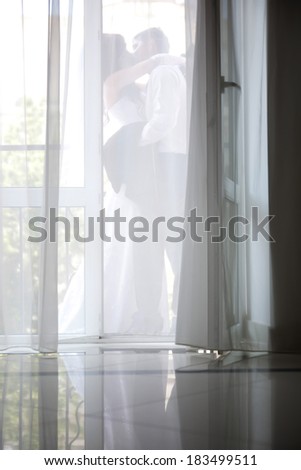 bride and groom kiss on the balcony for the curtain