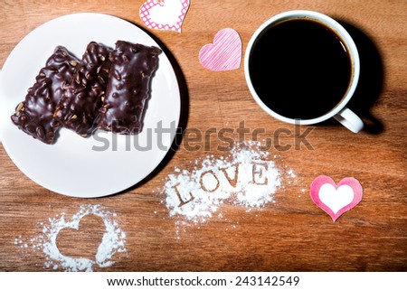Valentines day table setting. ?up of coffee and cookies on a wooden table with hearts valentines