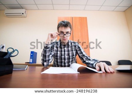 Office worker. Young office worker looking through glasses