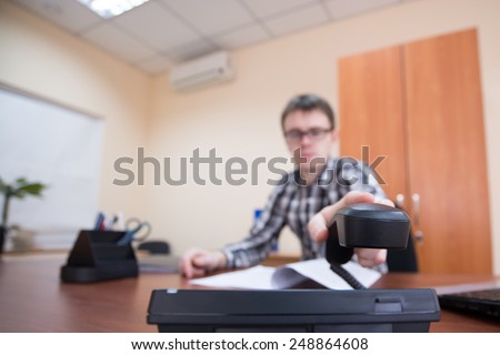 Office worker. Young office worker picks up the phone