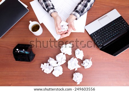 Crumpled sheets of paper. Office worker hands crumple sheets of paper at the table
