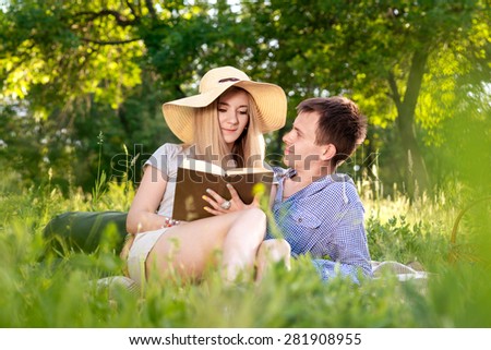 Young couple reading a book on nature