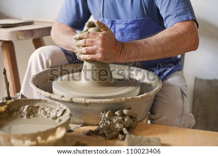 Clay in the potter\'s wheel and hand