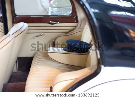 Back passenger seats with the driver\'s cap in an oldtimer luxury comfortable car.