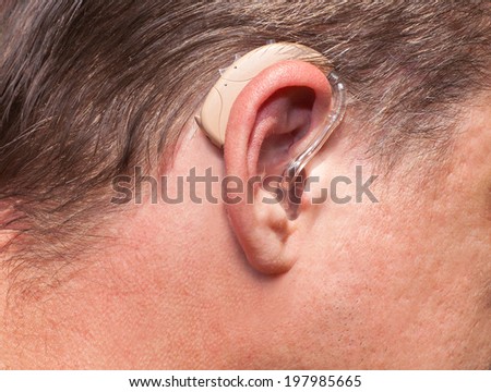 Close up of a middle-aged man\'s ear wearing hearing aid