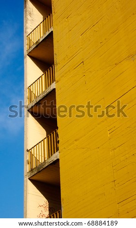 Abandoned yellow block of flats detail with balconies.
