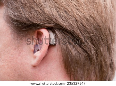 Close-up of a man ear with a high-tech digital hearing aid
