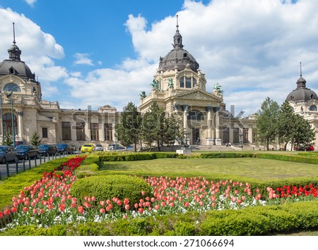 The Szechenyi Bath in Budapest, Hungary with a flower garden in the front.