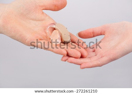 Giving a hearing aid by hand to hand