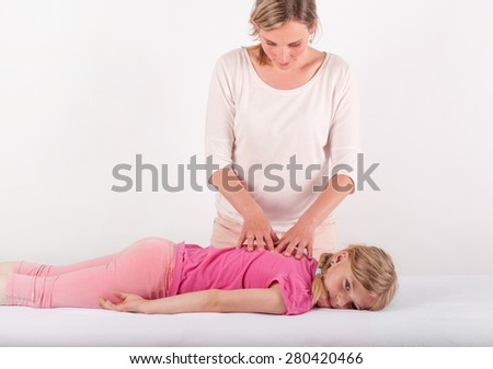 Small girl receives a Bowen therapy which is a holistic system of healing