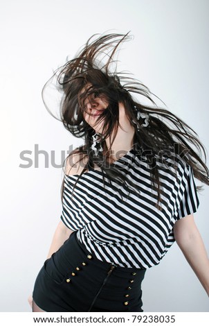 Beautiful teen girl shaking head with long hair on white background