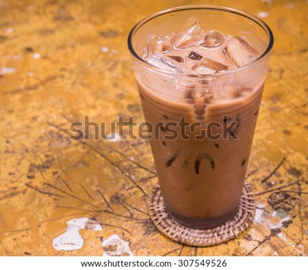 Mocha iced coffee on old wooden textured, vintage tone