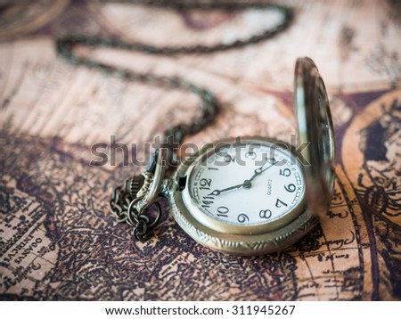 Antique Pocket Watch Clock On Old Treasure World Map Background.