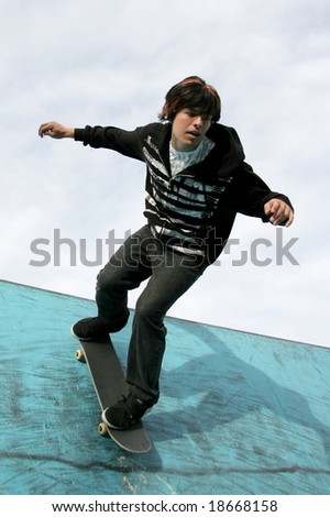 Young skater performing stunts in a blue skate bowl