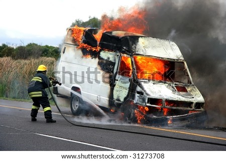 Fireman putting out van that is burning