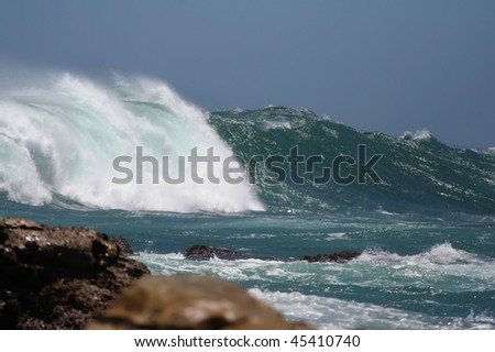 Huge stormy wave breaking violently at the coast