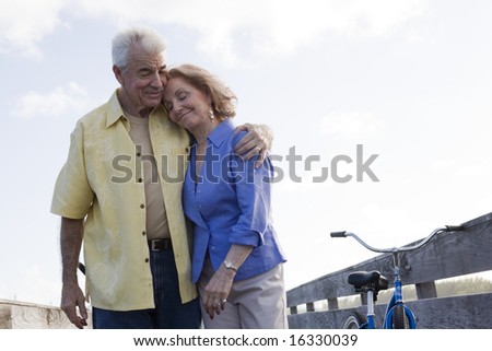 Senior couple walking on a boardwalk with bikes