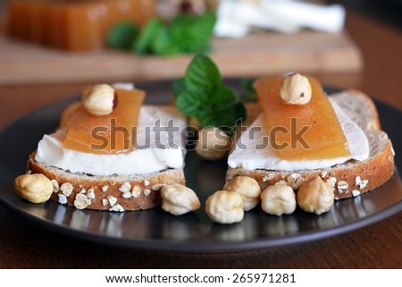 Quince And Fresh White Cheese On Bread Toast On A Brown Plate On The Wooden Table