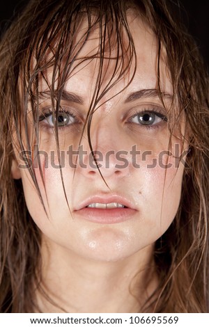 A close up of a woman\'s face with sweat running down her face