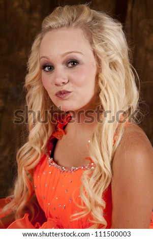A young teen girl in her formal dress with her lips puckered up for a kiss.