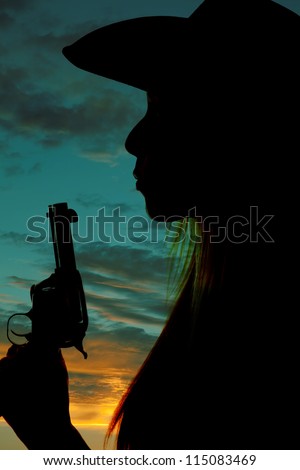 A silhouette of a woman blowing on the tip of her gun.