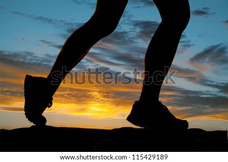 A woman running in the sunset legs silhouette.