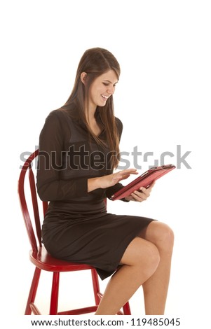 A woman working on her electronic tablet with a smile on her face.
