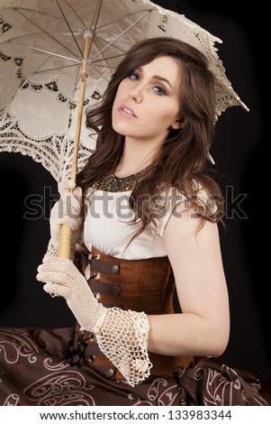 A woman with a serious expression on her face in her western dress and umbrella.