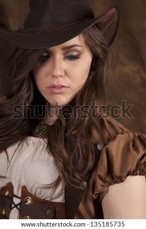 A close up of a woman looking down in her vintage clothing and cowgirl hat.