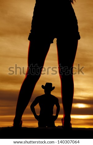 a silhouette of a cowboy in the middle of woman\'s legs.