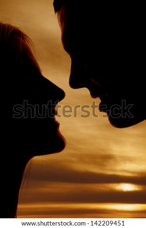 A silhouette of a man and woman\'s faces close up