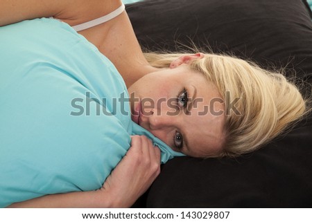 A woman laying on her pillow snuggling up to her pillow.