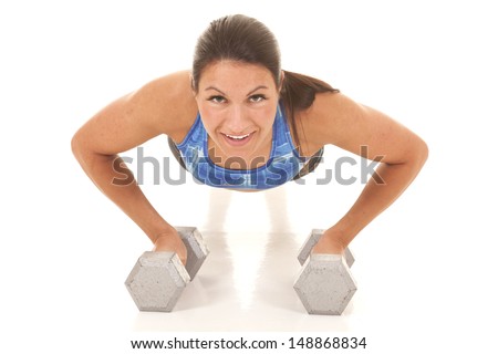a woman using her weights to do a push up, with a smile on her face.