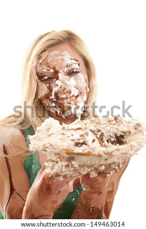 A woman has pie all over her face and is very messy