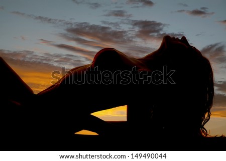 A woman upper body silhouette in the sunset.