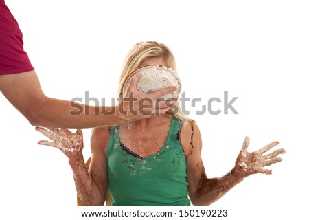 A person is putting a pie in a womans face.