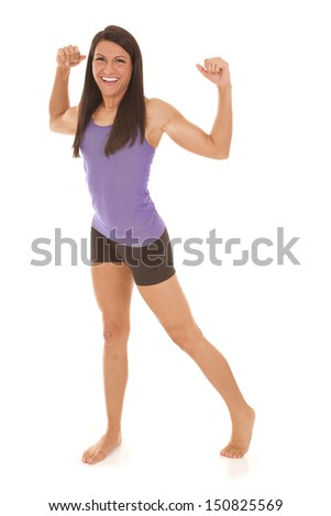 a woman in her fitness clothes flexing her arms with a smile on her face.