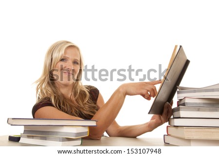 A woman with a smirk on her face pointing in a book.