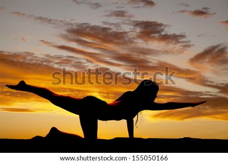 A silhouette of a woman stretching out her arm and leg.