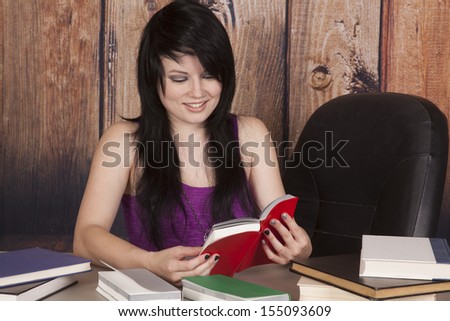 a woman laughing at one of the books from off the table.