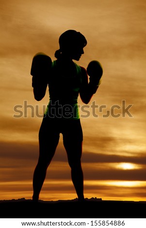 A woman with her boxing gloves in the outdoors.