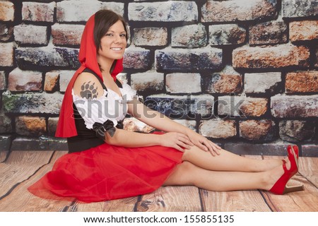 A woman sitting on the ground with her wolf paw tattoo showing.