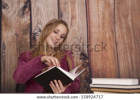 A woman at work holding on to a book flipping through pages.