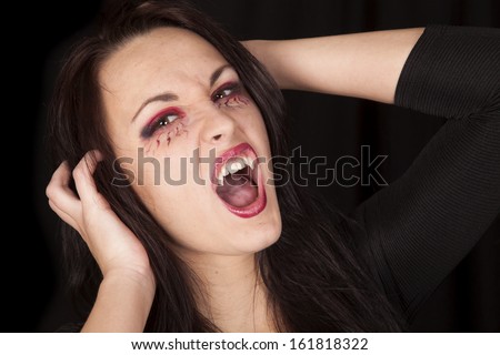 A woman vampire showing off her teeth with her mouth open.